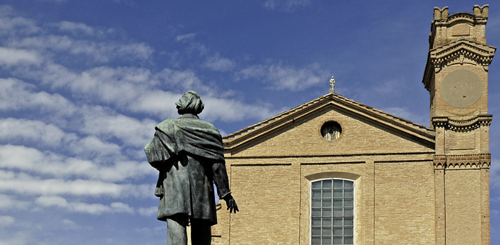 La statura di Quirico Filopanti con sullo sfondo la Chiesa di San Lorenzo